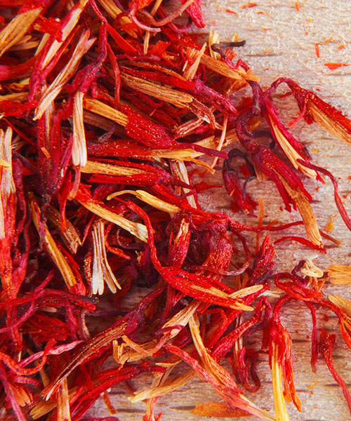 Closeup of whole saffron in vibrant red and orange hues. Gourmet Spice Company, Wholesale Food Distributor.